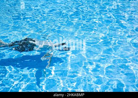 Junger Mann, der den Tag am Schwimmbad ausklingen lassen kann Stockfoto