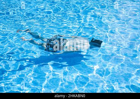 Junger Mann, der den Tag am Schwimmbad ausklingen lassen kann Stockfoto