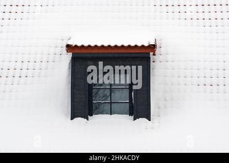 Dachgaube auf einem Dach unter einer Schicht Neuschnee Stockfoto