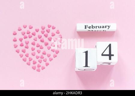 Romantische Komposition Holzwürfel Kalender 14. Februar und Paar Holzliebhaber Figur Kaninchen auf lila Hintergrund. Konzept Valentinskarte. Bis Stockfoto