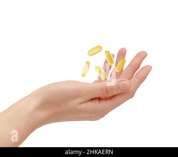 Omega 3 Pillen schweben über weibliche Hand isoliert auf weißem Hintergrund. Gesundheits- und Behandlungskonzept Stockfoto