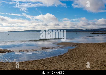 Sandbanks, Poole, Dorset, Großbritannien. 3rd. Februar 2022. Wetter in Großbritannien: Ein wenig Sonnenschein, um den Tag am Strand von Sandbanks zu beginnen, während der Himmel im Meer reflektiert. Quelle: Carolyn Jenkins/Alamy Live News Stockfoto