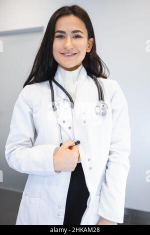 Porträt einer attraktiven jungen Ärztin im weißen medizinischen Mantel Stockfoto