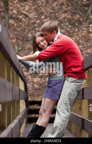 Junges Paar umarmt auf Brücke Stockfoto