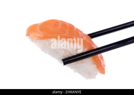 Sushi, das von Essstäbchen gehalten wird, isoliert auf Weiß Stockfoto