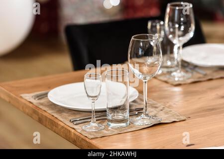 Glasteller auf einem Holztisch. Sauber und leer. Gemütliche Atmosphäre. Serviert ein Bankett Stockfoto