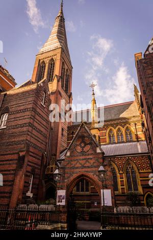 All Saints Church, eine denkmalgeschützte anglo-katholische Kirche, die von William Butterfield im hoch viktorianischen gotischen Stil entworfen und 1850s in London, U, erbaut wurde Stockfoto