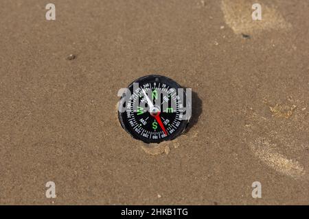 Kompass nach Südwesten am Strand Stockfoto