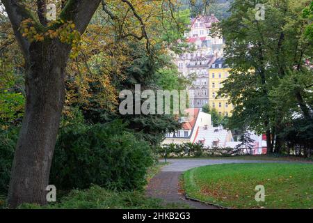 Karlovy Vary (Karlsbad) in Tschechien: Elegante Hausfassaden entlang Na Vyhlídce, die durch die Bäume eines Parks gesehen werden Stockfoto