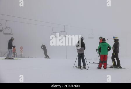 03. Februar 2022, Sachsen, Schöneck: Skifahrer stehen auf einer Skipiste in der SkiWelt Schöneck im Vogtland. Derzeit profitieren die sächsischen Skigebiete vor allem von Urlaubsgästen aus Berlin und Brandenburg. Nach der späten Eröffnung Mitte Januar aufgrund von Corona haben Liftbetreiber, Hoteliers und Gastronomen viel Nachholbedarf und hoffen auf eine möglichst lange Saison. Obwohl zahlreiche Gäste kommen, gibt es noch Raum für Verbesserungen, so der Geschäftsführer der SkiWelt. Skifahren ist derzeit in Sachsen unter 2G Jahren möglich. Foto: Jan Woitas/dpa-Zentralbild/d Stockfoto