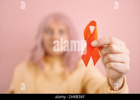 Frau Hand hält rotes Band für den dezember World Aids Day, Krebs Bewusstsein Monat. Gesundheitsfürsorge und Weltkrebstag Konzept. Weltgesundheitstag. Stockfoto