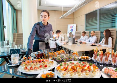 Ein Restaurantkellner serviert ein Bankett außerhalb des Hotels im Büro Stockfoto