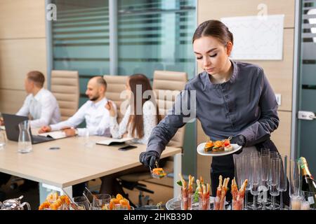 Ein Restaurantkellner serviert ein Bankett außerhalb des Hotels im Büro Stockfoto