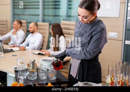 Ein Restaurantkellner serviert ein Bankett außerhalb des Hotels im Büro Stockfoto