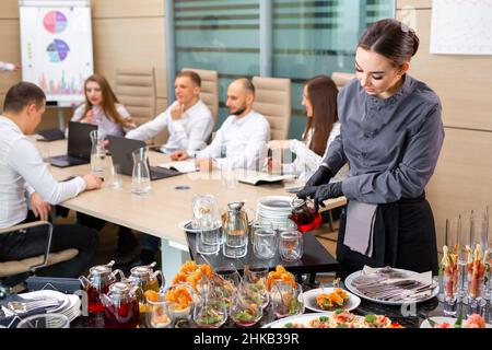 Ein Restaurantkellner serviert ein Bankett außerhalb des Hotels im Büro Stockfoto