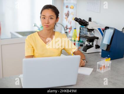 Assistentin der Tierärztin mit Laptop im Labor Stockfoto