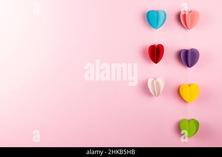 Verschiedene Farben Papier Herzen auf rosa Hintergrund mit Kopierraum. Valentinstag, Muttertag und Feiertag Grußkarte. Mock up. Stockfoto