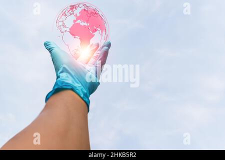 Medizinische Hand in medizinischen Handschuhen, die das COVID-19-Konzept erreichen. Stockfoto