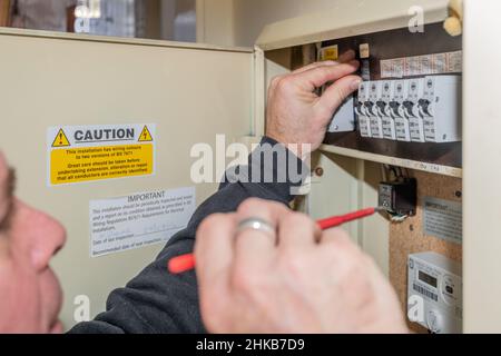 3rd. Februar 2022. Die Obergrenze für die Energiepreise, die begrenzt, wie viel Anbieter pro Einheit berechnen, steigt aufgrund eines beispiellosen Anstiegs der Gaspreise um 54 %. Ein Elektriker arbeitet an einem inländischen Sicherungskasten für Verbraucher Eastbourne East Sussex, Großbritannien. Kredit: Reppans/Alamy Live Nachrichten Stockfoto