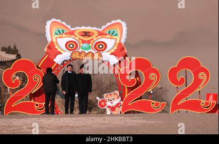 Dunhuang, Chinas Provinz Gansu. 3rd. Februar 2022. Menschen besuchen den Berg Mingsha und die Halbmond-Quelle in der Stadt Dunhuang, nordwestlich der chinesischen Provinz Gansu, 3. Februar 2022. Menschen in ganz China nahmen an verschiedenen Veranstaltungen Teil, um das chinesische Mondneujahr zu feiern. Quelle: Zhang Xiaoliang/Xinhua/Alamy Live News Stockfoto