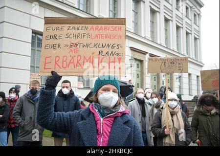 03. Februar 2022, Sachsen-Anhalt, Halle (Saale): Teilnehmerin an der Kundgebung gegen das geplante Sparpaket an der Universität Halle mit ihrem Protestschild. Die Kundgebung wurde vom Aktionsbündnis #MLUnterfinanziert aufgerufen, das gegen die Kürzung der Personalgelder der Landesregierung in fast allen Bereichen der Universität protestiert. Anlass für die Kundgebung ist die anschließende Senatssitzung der Martin-Luther-Universität Halle-Wittenberg. Foto: Heiko Rebsch/dpa-Zentralbild/dpa Stockfoto