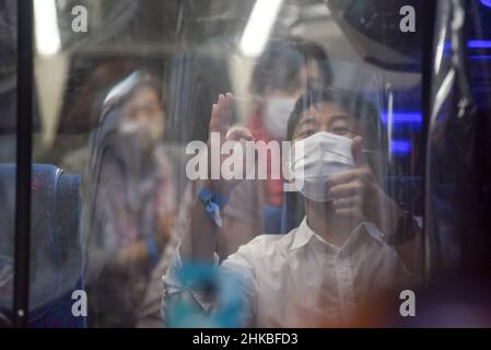 Badung, Bali, Indonesien. 3rd. Februar 2022. Ein Reisender aus Japan winkte in einem Bus, als er am internationalen Flughafen Bali I Gusti Ngurah Rai ankam. Der erste reguläre internationale Flug von Garuda Indonesia Airways, Airbus 330-300 mit der Seriennummer GA 881, vom japanischen Flughafen Narita kommt am Flughafen I Gusti Ngurah Rai, Bali an. Der Flug, der um 9:15 Uhr Ortszeit in Tokio startet und um 16:33 Uhr in Bali eintrifft, umfasst Menschen aus der Reisebranche, die aus 6 japanischen Bürgern und 6 indonesischen Bürgern bestehen, die in Japan leben. Dieser Flug gilt als erster internationaler Flug Stockfoto