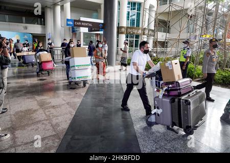 Badung, Bali, Indonesien. 3rd. Februar 2022. Eine Gruppe von Reisenden aus Japan bringt ihr Gepäck bei der Ankunft am internationalen Flughafen Bali I Gusti Ngurah Rai mit. Der erste reguläre internationale Flug von Garuda Indonesia Airways, Airbus 330-300 mit der Seriennummer GA 881, vom japanischen Flughafen Narita kommt am Flughafen I Gusti Ngurah Rai, Bali an. Der Flug, der um 9:15 Uhr Ortszeit in Tokio startet und um 16:33 Uhr in Bali eintrifft, umfasst Menschen aus der Reisebranche, die aus 6 japanischen Bürgern und 6 indonesischen Bürgern bestehen, die in Japan leben. Dieser Flug gilt als erster internationaler fli Stockfoto