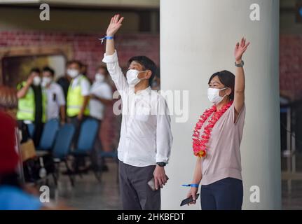 Badung, Bali, Indonesien. 3rd. Februar 2022. Zwei Reisende aus Japan winkten bei der Ankunft am internationalen Flughafen Bali I Gusti Ngurah Rai mit den Händen. Der erste reguläre internationale Flug von Garuda Indonesia Airways, Airbus 330-300 mit der Seriennummer GA 881, vom japanischen Flughafen Narita kommt am Flughafen I Gusti Ngurah Rai, Bali an. Der Flug, der um 9:15 Uhr Ortszeit in Tokio startet und um 16:33 Uhr in Bali eintrifft, umfasst Menschen aus der Reisebranche, die aus 6 japanischen Bürgern und 6 indonesischen Bürgern bestehen, die in Japan leben. Dieser Flug gilt als der erste internationale Flug, der Stockfoto