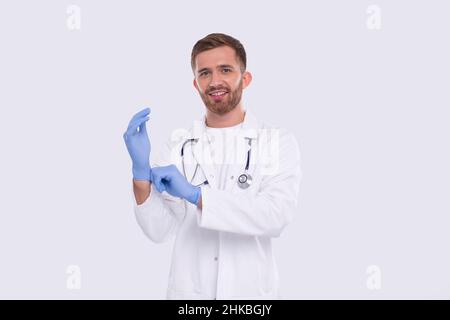 Der Arzt zieht Handschuhe isoliert an. Man Doctor Protection Workwear. Medizinisches Konzept Corona Virus. Handschuhe Stockfoto