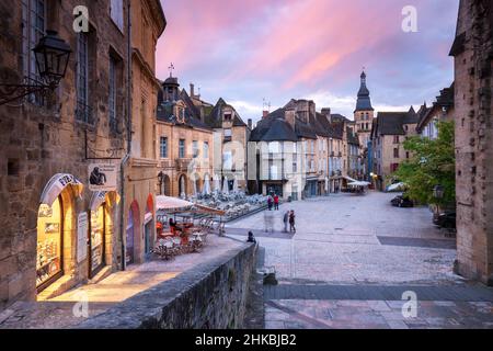 Sarlat Hauptplatz mit beleuchteten Geschäften und Sarlat Kathedrale bei Sonnenuntergang Sarlat Dordogne Frankreich Stockfoto