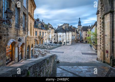 Sarlat Hauptplatz ohne Menschen mit beleuchteten Geschäften und Sarlat Kathedrale bei Sonnenaufgang Sarlat Dordogne Frankreich Stockfoto