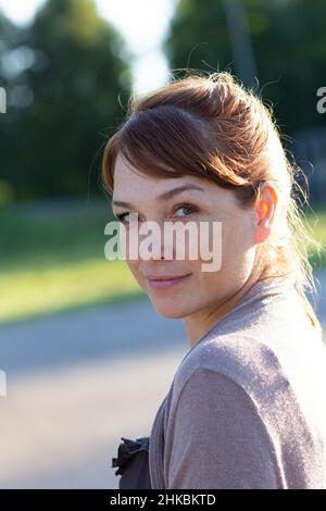 Porträt einer schönen Frau mittleren Alters mit einem ruhigen und lächelnden Gesicht, das auf die Kamera blickt Stockfoto
