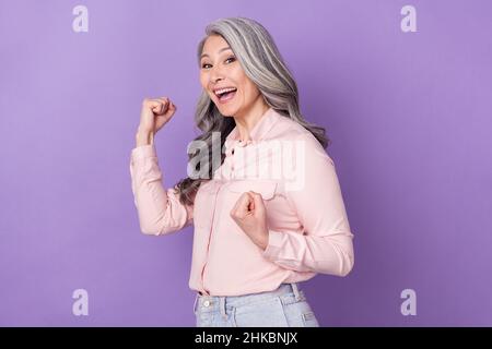 Portrait von attraktiven fröhlich glücklich grauhaarige Frau jubeln Spaß isoliert über violett lila Farbe Hintergrund Stockfoto