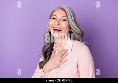 Porträt der attraktiven fröhlich erfreut grauhaarige Frau lachen Spaß isoliert über violett lila Farbe Hintergrund Stockfoto