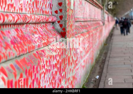 National Covid Memorial Wall an einem grimmigen bewölkten Tag in Lambeth, London, Großbritannien. Rote Herzen, die auf eine Wand gezogen werden, die jeden Tod von COVID 19 darstellt. Länge Stockfoto