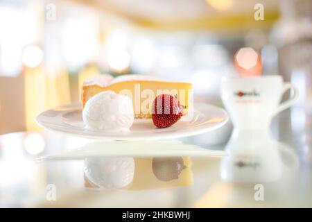 Käsekuchen mit Eis und Erdbeere und einer Tasse Kaffee Stockfoto