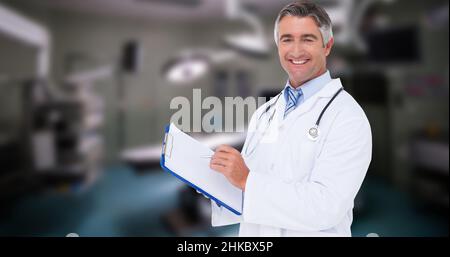 Porträt eines kaukasischen lächelnden reifen männlichen Arztes mit Zwischenablage im Krankenhaus Stockfoto