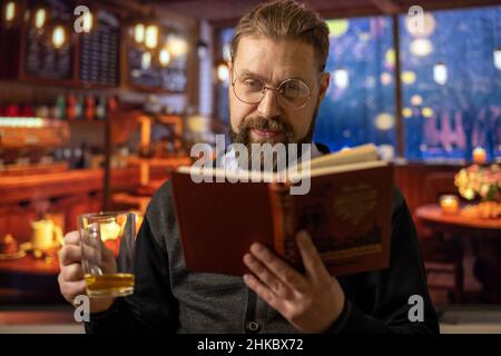 Mann im Café mit Buch Stockfoto