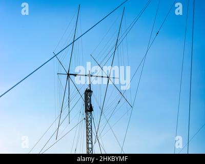 Eine hohe Funkantenne mit Schinkenstrahler gegen einen blauen Himmel Stockfoto