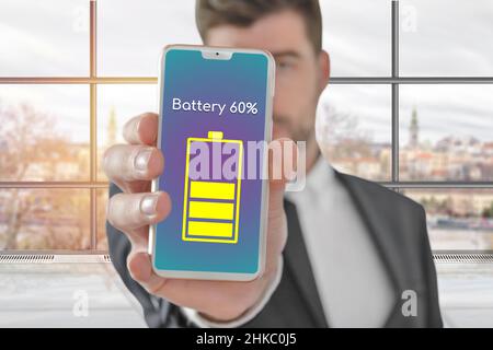 Geschäfts- und Technologiekonzept Geschäftsmann zeigt Smartphone mit 60 Prozent aufgeladenem Akku Stockfoto
