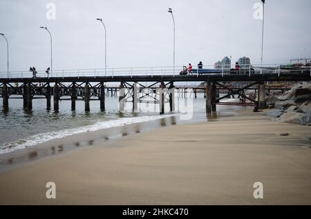 Valparaiso, Chile - Februar 2020: Pier namens Muelle Portales am Strand von Playa Caleta Portales in der Nähe des Fischmarktes. Sandstrand an der chilenischen Küste Stockfoto