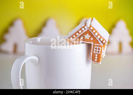 Lebkuchenhütten und eine Tasse Milch, Nahaufnahme. Weihnachtsfeier Konzept Stockfoto