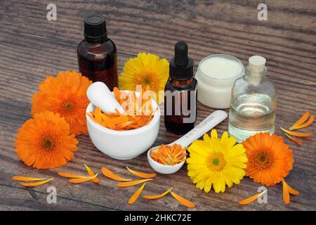 Calendula Blumen für Aromatherapie Hautpflege mit ätherischen Ölflaschen und Salbe. Heilt Wunden, Akne, Ekzeme und stimuliert Kollagen. Stockfoto