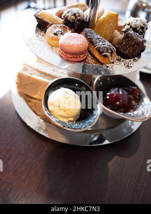 Köstlicher Kuchenstand voller ausgefallener Kuchen und Sandwiches für englischen Nachmittagstee. Stockfoto