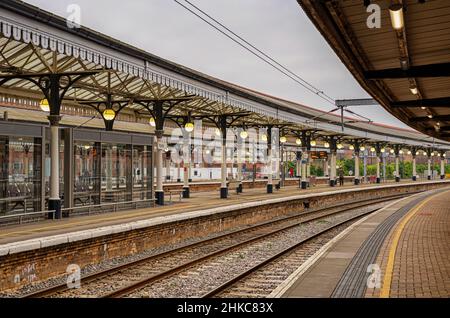 York Bahnhof Plattform mit aufwendigen 19th Jahrhundert Vordächer, die Kurve in diese Entfernung. Ein moderner Warteraum befindet sich auf der anderen Seite der Schienen. Stockfoto