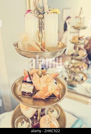 Köstlicher Kuchenstand voller ausgefallener Kuchen und Sandwiches für englischen Nachmittagstee. Stockfoto