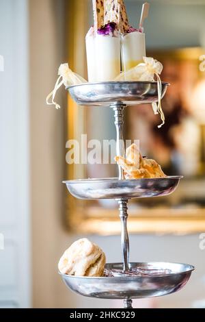 Köstlicher Kuchenstand voller ausgefallener Kuchen und Sandwiches für englischen Nachmittagstee. Stockfoto