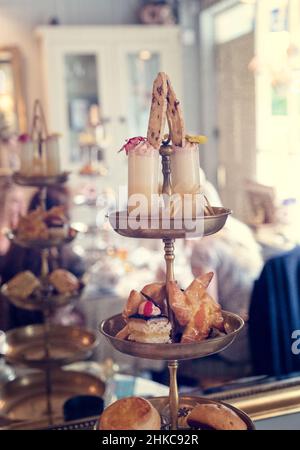 Köstlicher Kuchenstand voller ausgefallener Kuchen und Sandwiches für englischen Nachmittagstee. Stockfoto