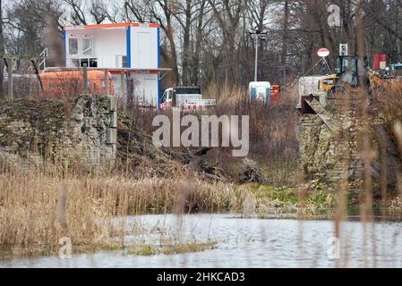 02. Februar 2022, Brandenburg, Oranienburg: Schilf wächst am Rande der Baustelle der Friedensthaler Schleuse an der Havel neben den Mauerresten. Nach Angaben der Stadt handelt es sich bei der aktuellen Rekonstruktion der Schleuse, die 1879 erbaut und 1959 stillgelegt wurde, um ein einzigartig umfangreiches Infrastrukturprojekt, das im vergangenen Jahr mit der Räumung von Sprengkörpern begonnen hatte. Nach dem Abriss soll bis Herbst 2023 eine komplett neue Schleuse gebaut werden. Damit wird der Hafen von Oranienburg mit den Ruppiner Gewässern verbunden, was insbesondere dem Wassertourismus zugute kommen soll. Foto: Soeren Stache/dpa-Zen Stockfoto