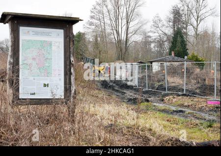 02. Februar 2022, Brandenburg, Oranienburg: Am Rande der Baustelle der Friedensthaler Schleuse steht neben der Informationstafel für Wanderer ein Bauzaun. Nach Angaben der Stadt handelt es sich bei der aktuellen Rekonstruktion der Schleuse, die 1879 erbaut und 1959 stillgelegt wurde, um ein einzigartig umfangreiches Infrastrukturprojekt, das im vergangenen Jahr mit der Räumung von Sprengkörpern begonnen hatte. Nach dem Abriss soll bis Herbst 2023 eine komplett neue Schleuse gebaut werden. Damit wird der Hafen von Oranienburg mit den Ruppiner Gewässern verbunden, was insbesondere dem Wassertourismus zugute kommen soll. Foto: Soeren Stache/ Stockfoto